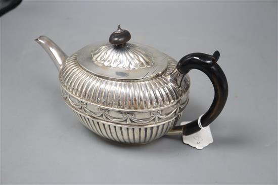 A Victorian fluted silver oval teapot by William Hunter, London, 1886, gross 20.5oz, with engraved initials.